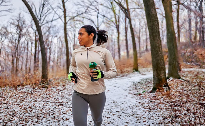 Mujer corre por el bosque en invierno