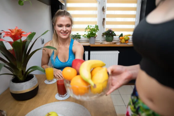 Deportista frente a una cesta de fruta