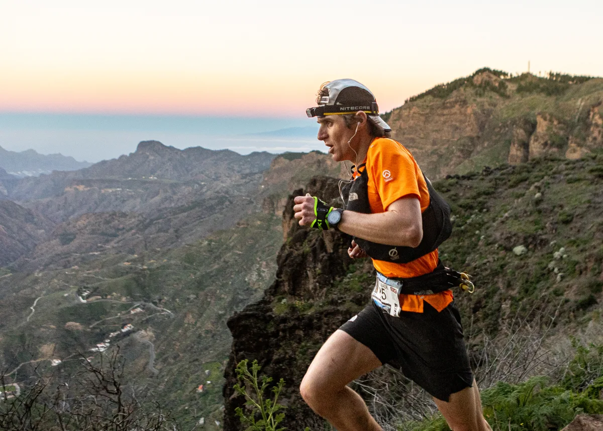 Un corredor en plena acción durante la The North Face Transgrancanaria 2026, con el paisaje natural de fondo.